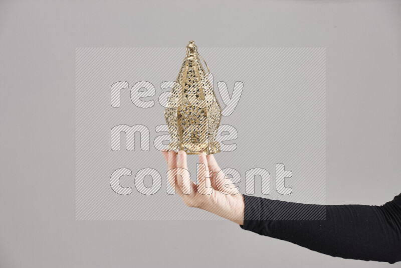 A woman in black abaya holding different ramadan lanterns in different positions