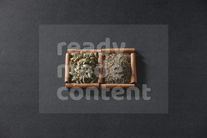 2 squares of cinnamon sticks full of cumin and cardamom on black flooring