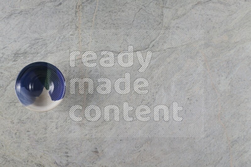 وعاء فخاري متعدد الألوان على خلفية من الرخام الرمادي