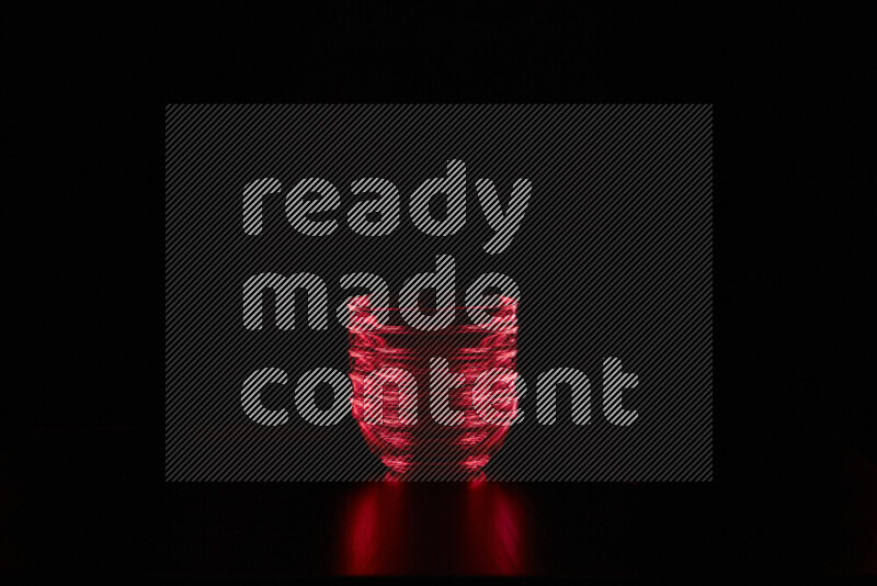 Glassware with rim light in red against black background