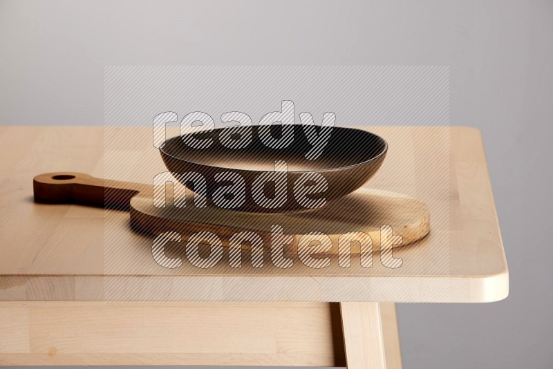 brass plate placed on a  wooden oval cutting board on the edge of wooden table