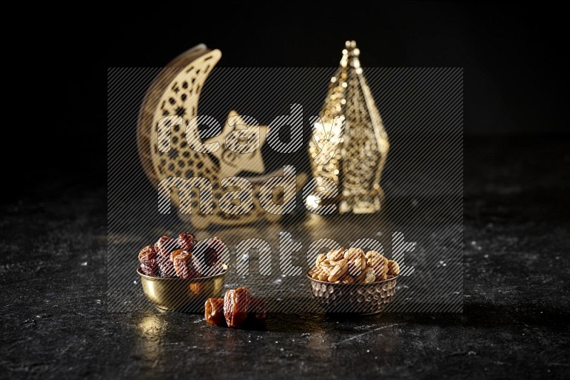 Dates in a metal bowl with cashews beside golden lanterns in a dark setup