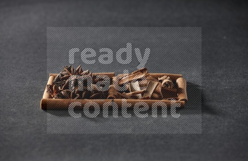 2 squares of cinnamon sticks full of star anise and cinnamon on black flooring