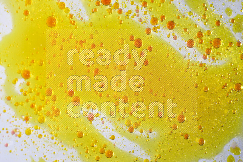 Close-ups of abstract yellow and red watercolor drops on oil Surface on white background