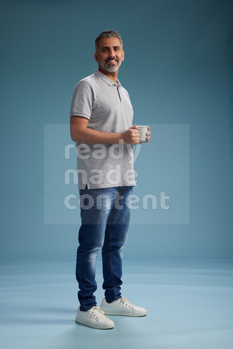 Man Standing drinking coffee on blue background