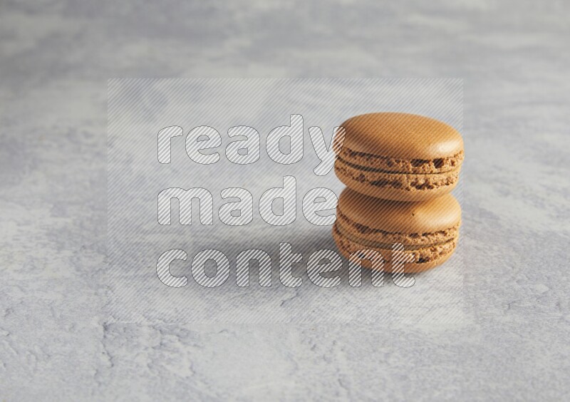 45º Shot of two Brown Maple Taffy macarons  on white  marble background