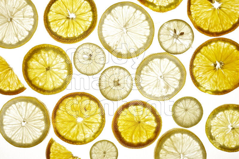 Mixed vegetables and fruits slices on illuminated white background