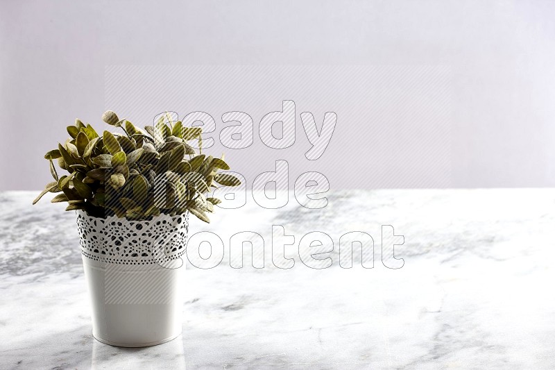 Artificial Plant in White Decorative Pot on Light Grey Marble Background 45 degree angle