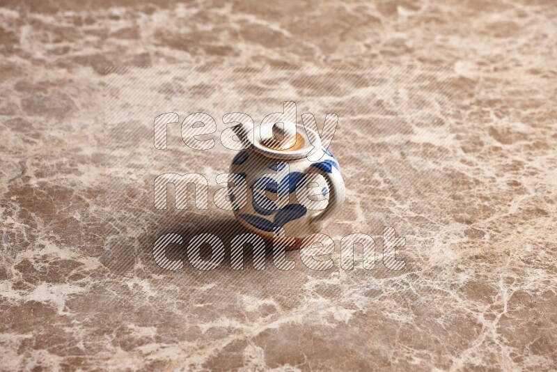 إبريق شاي فخاري على خلفية رخام بيج