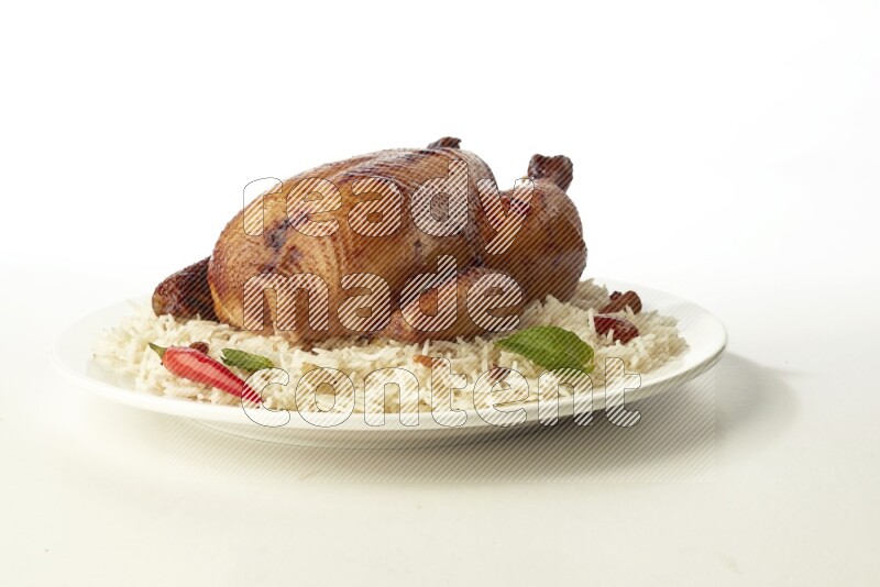 white  basmati Rice with  whole roasted chicken  on a white rounded plate direct on white background