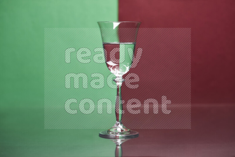 The image features a clear glassware filled with water, set against green and dark red background