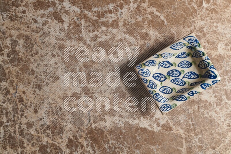 A decorative pottery plate on beige marble background