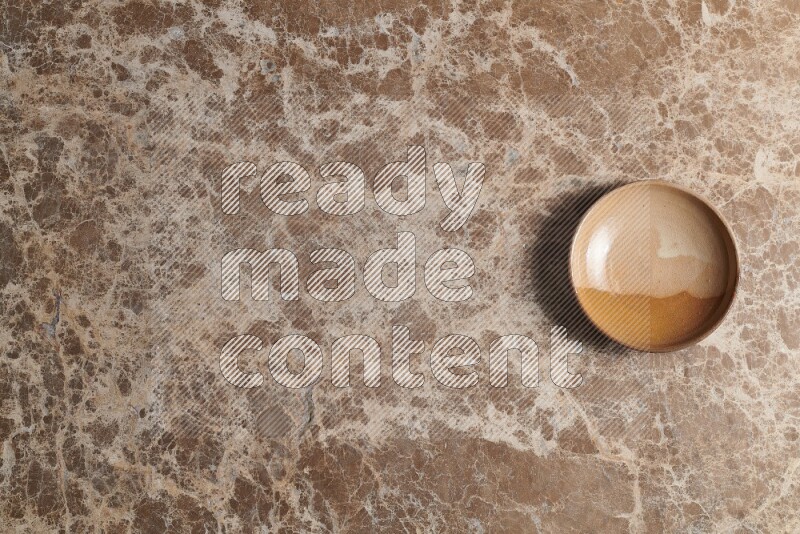 A multicolored pottery plate on beige marble background