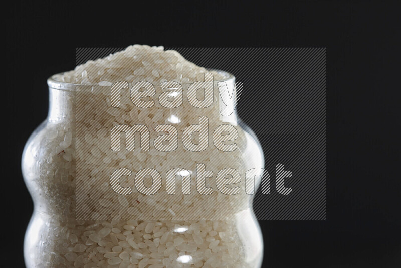 أرز أبيض في وعاء زجاجي على خلفية سوداء