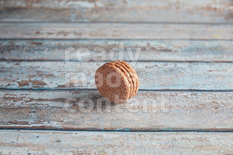 45º Shot of Brown Hazelnuts macaron on light blue wooden background