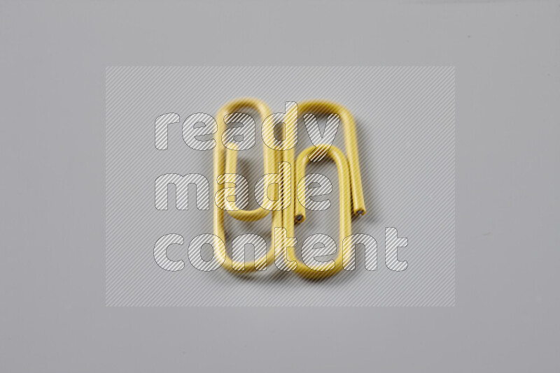 Yellow paper clips isolated on a grey background