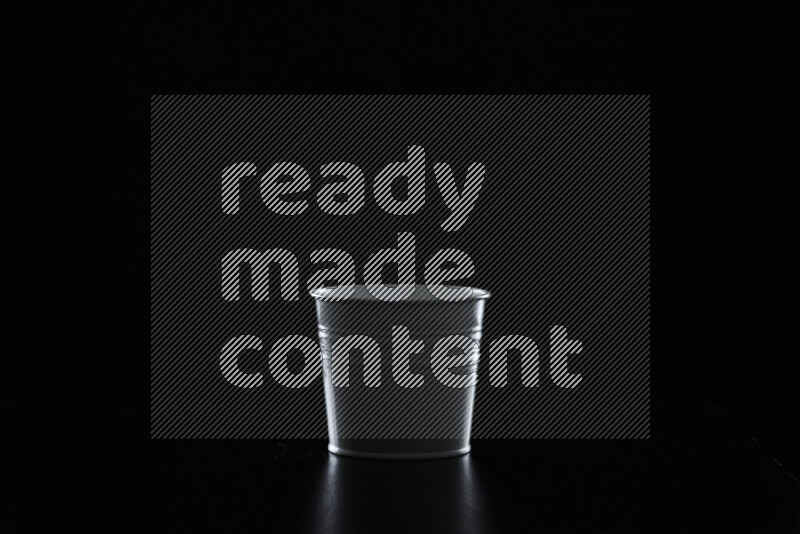 A plant pot with colored rim light against black background