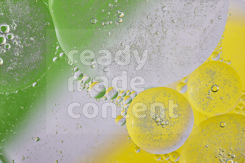 Close-ups of abstract oil bubbles on water surface in shades of yellow, green and white