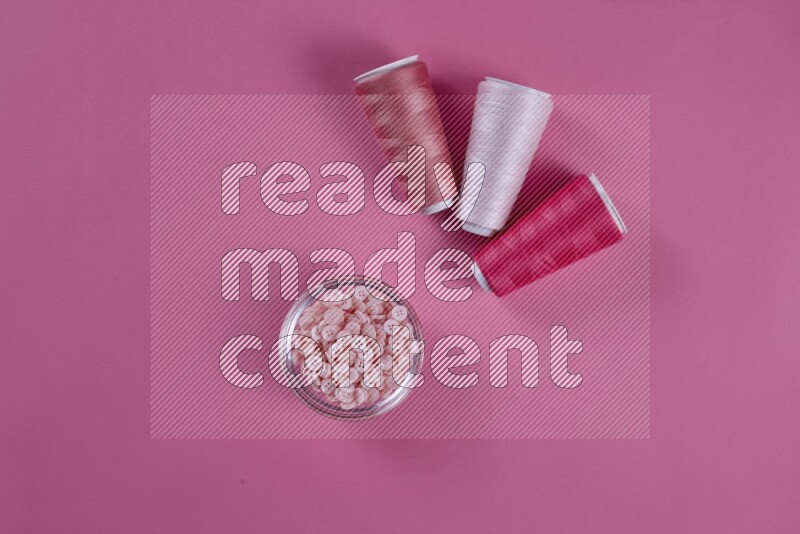 مجموعة من أدوات الخياطة والتفصيل زهرية اللون على خلفية زهرية