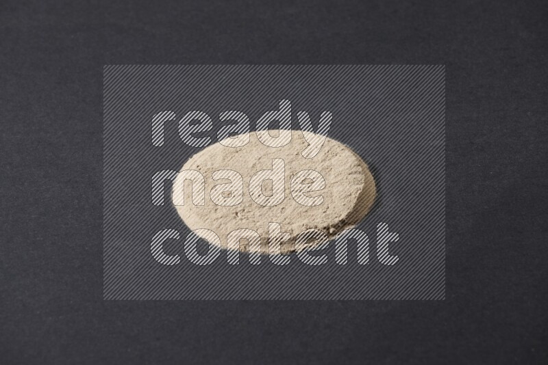 Garlic powder in a circle shape on a black flooring