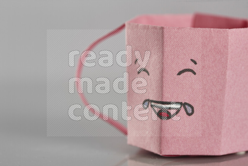 Origami cup on grey background