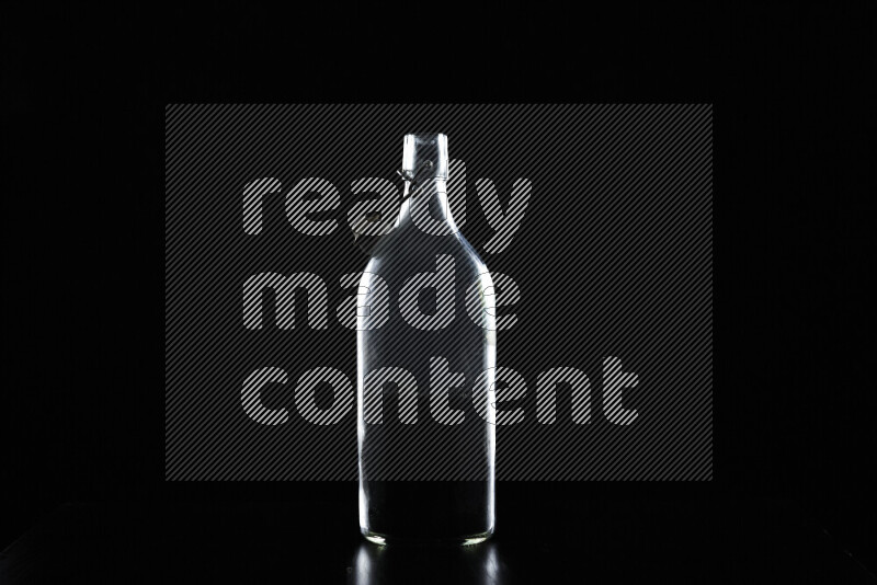 Water bottle with colored rim light against black background