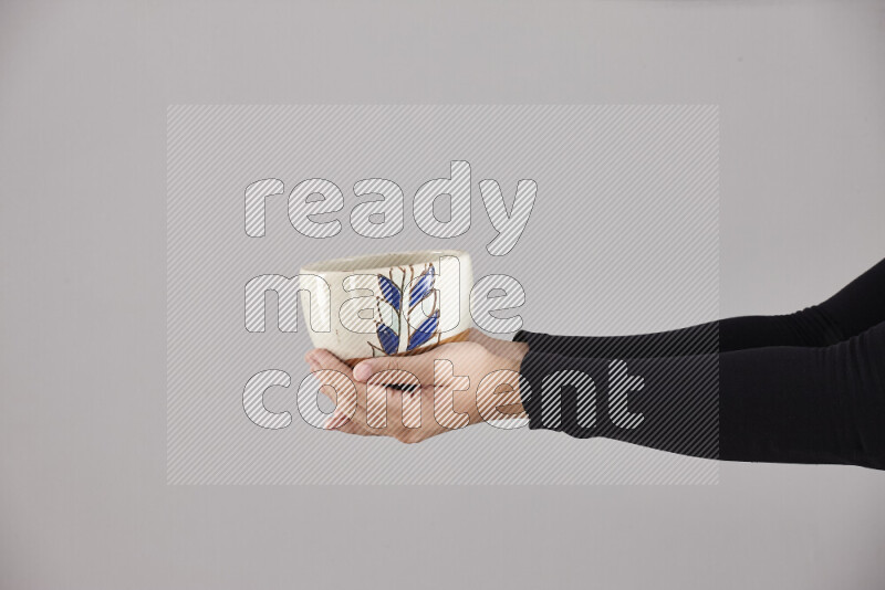 A woman in black abaya holding different pottery essentials in different positions
