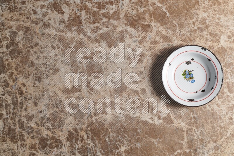 A vintage metal plate on beige marble background