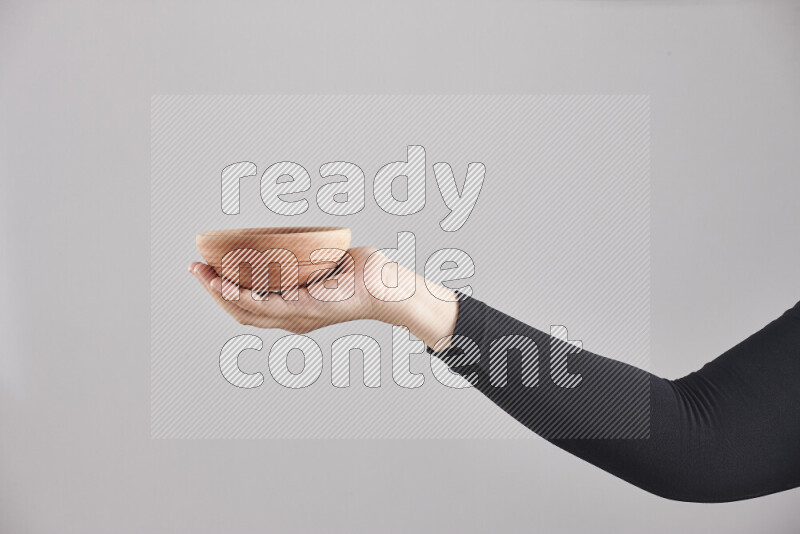 A woman in black abaya holding different wooden essentials in different positions