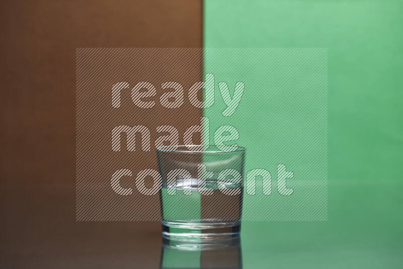 The image features a clear glassware filled with water, set against brown and green background