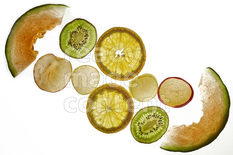 Mixed fruits slices on illuminated white background