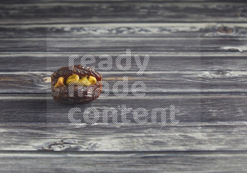 pistachio stuffed madjoul date on a wooden grey background