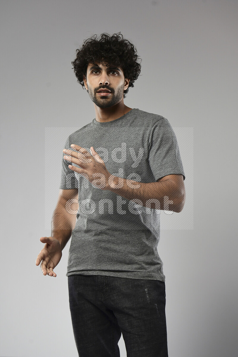 A man wearing casual standing and making a hand gesture on white background
