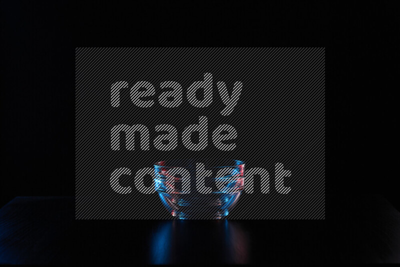 Glassware with rim light in red and blue against black background