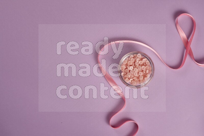 مجموعة من أدوات الخياطة والتفصيل زهرية وأرجوانية اللون على خلفية أرجوانية