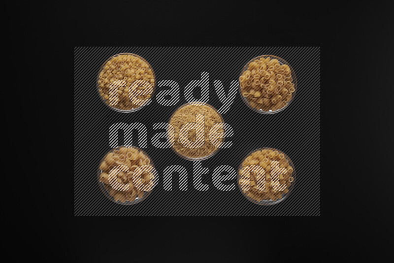 أنواع مختلفة من المعكرونة في أوعية زجاجية علي خلفية سوداء