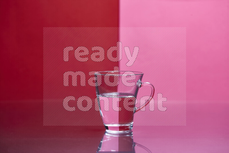 The image features a clear glassware filled with water, set against red and pink background