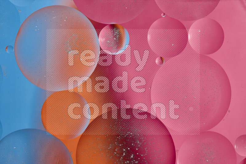 لقطات مقربة لفقاعات من الزيت على سطح الماء باللون الأزرق والبرتقالي والوردي