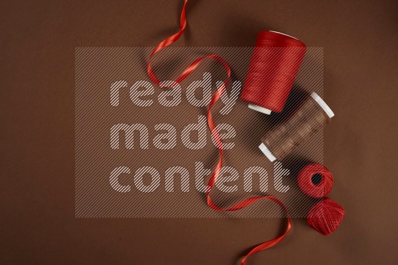 Red sewing supplies on brown background