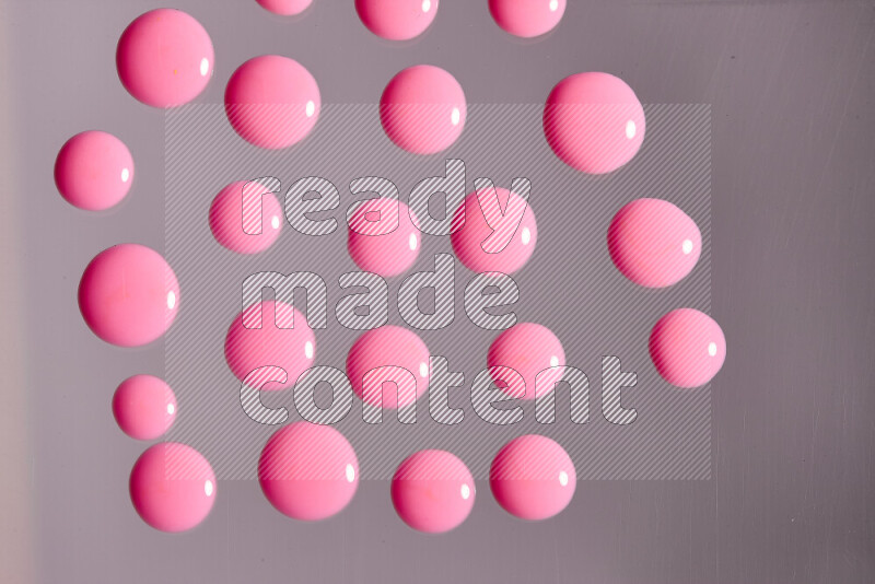 لقطات مقربة لقطرات من اللون الوردي على الخلفية