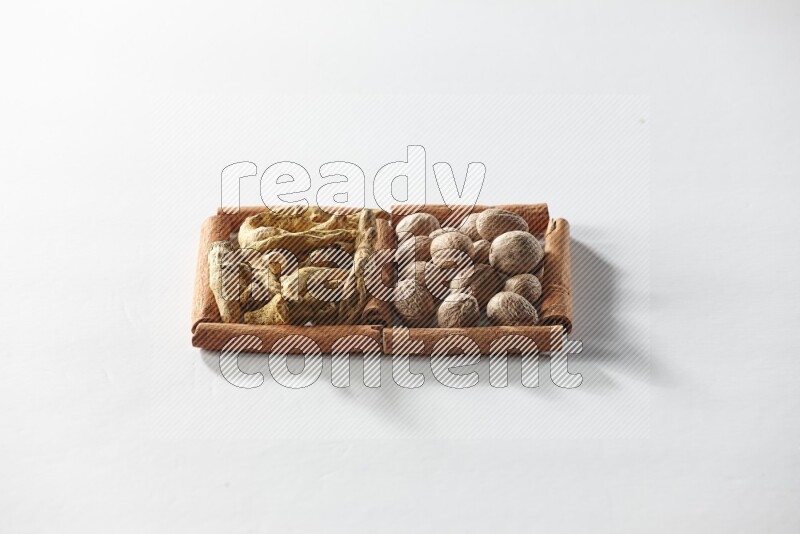 2 squares of cinnamon sticks full of turmeric fingers and nutmegs on white flooring