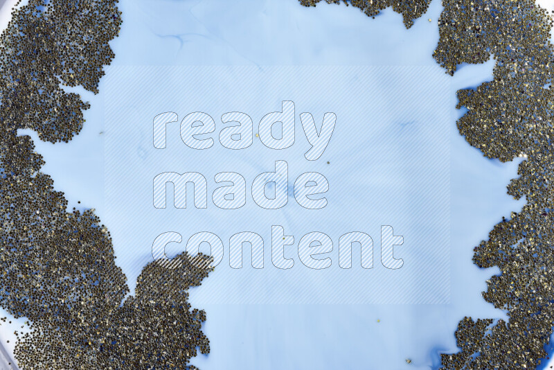 لقطة مقربة لبريق ذهبي متلألئ منتشر على خلفية من اللون الأزرق في حركات دائرية