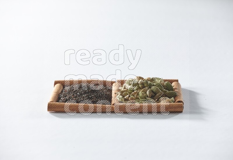 2 squares of cinnamon sticks full of black tea and cardamom on white flooring