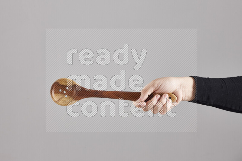 A woman in black abaya holding different wooden essentials in different positions