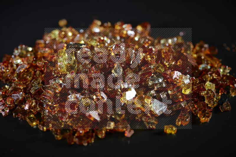 قطع زجاج برتقالية شفافة متناثرة على خلفية سوداء