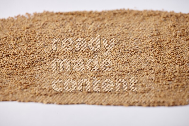 Mustard seeds spread on a white flooring