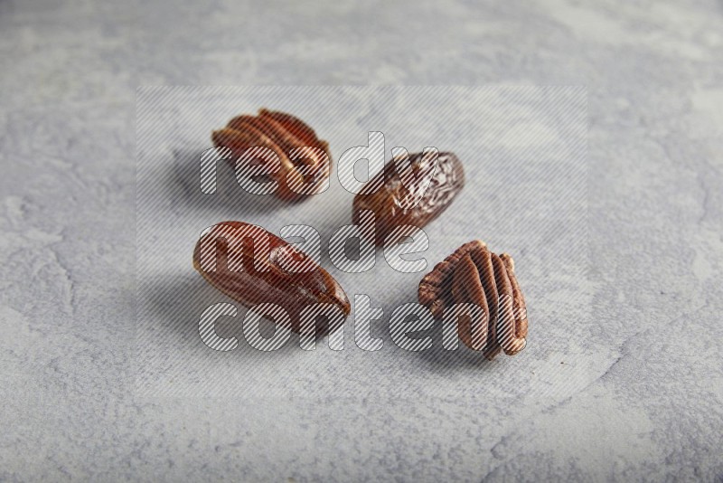 group of pecan stuffed dates plain and covered with dark and white chocolate  on alight grey background