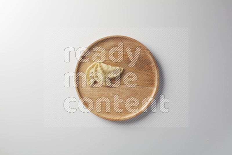 Three Sambosas on a wooden round plate on a white background