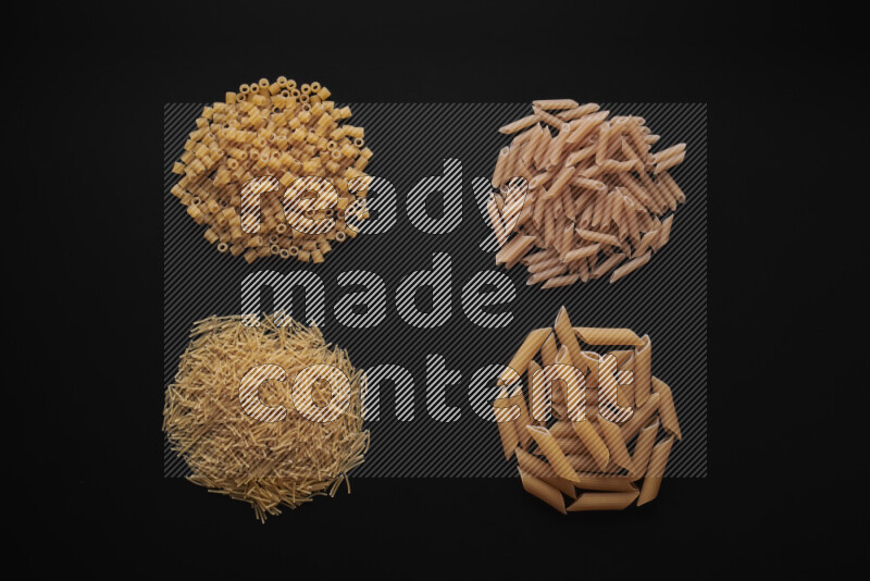 Different pasta types in bunches on black background
