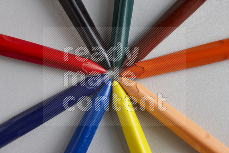 An arrangement of wax crayons in different colors on grey background
